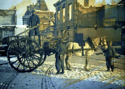 Three French soldiers in a street with damaged buildings, Chauny, Aisne, France, 1917 by Fernand Cuville